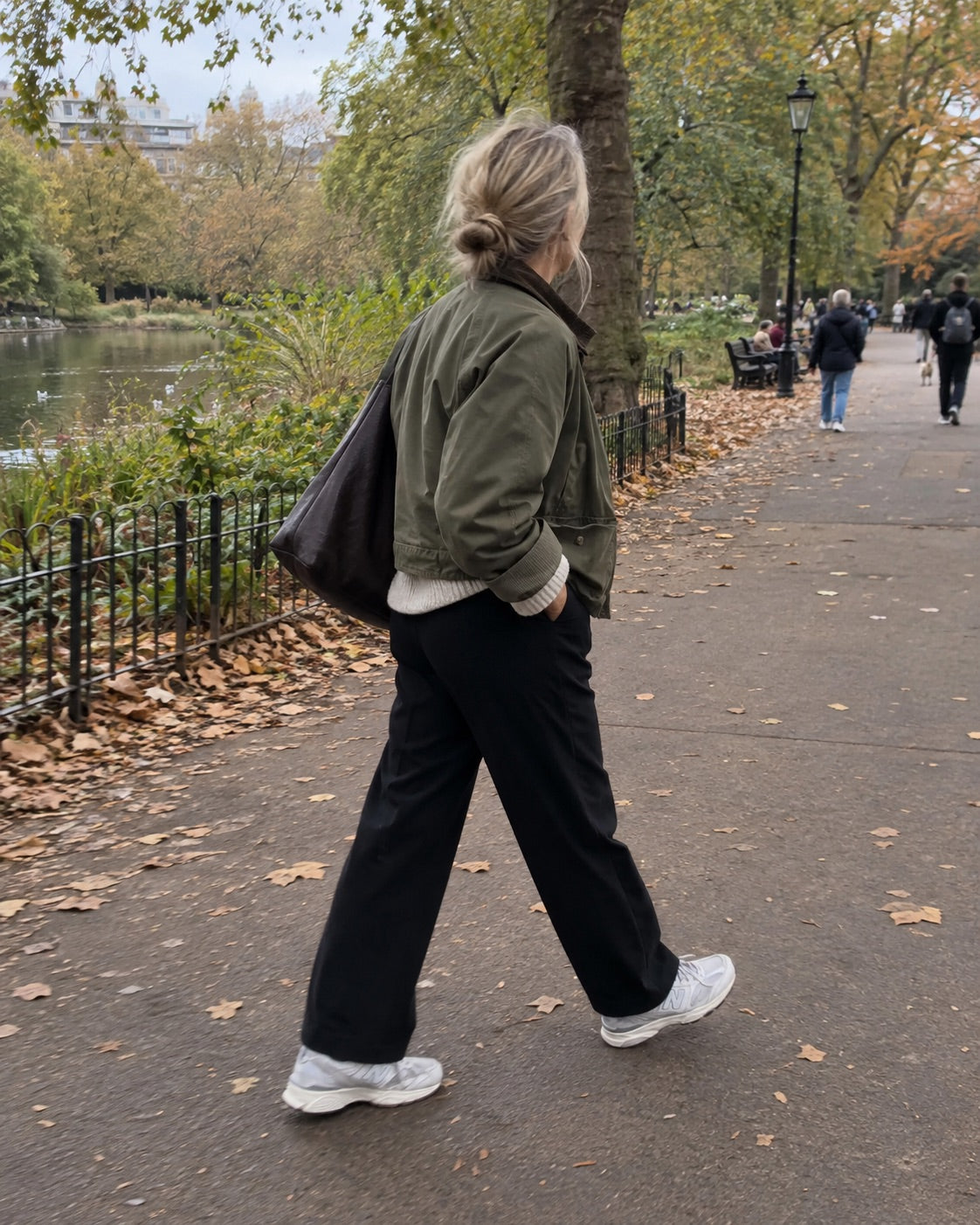 Woman wearing an olive jacket and black trousers on an autumn walk